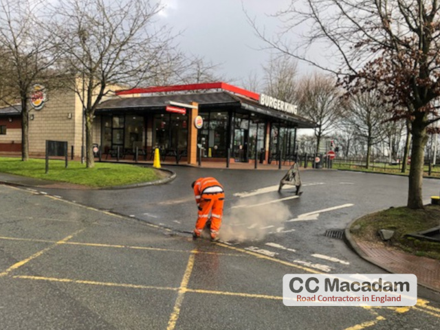 Tarmac company repairing car park, man fixing carpark with tarmac, Sheffield